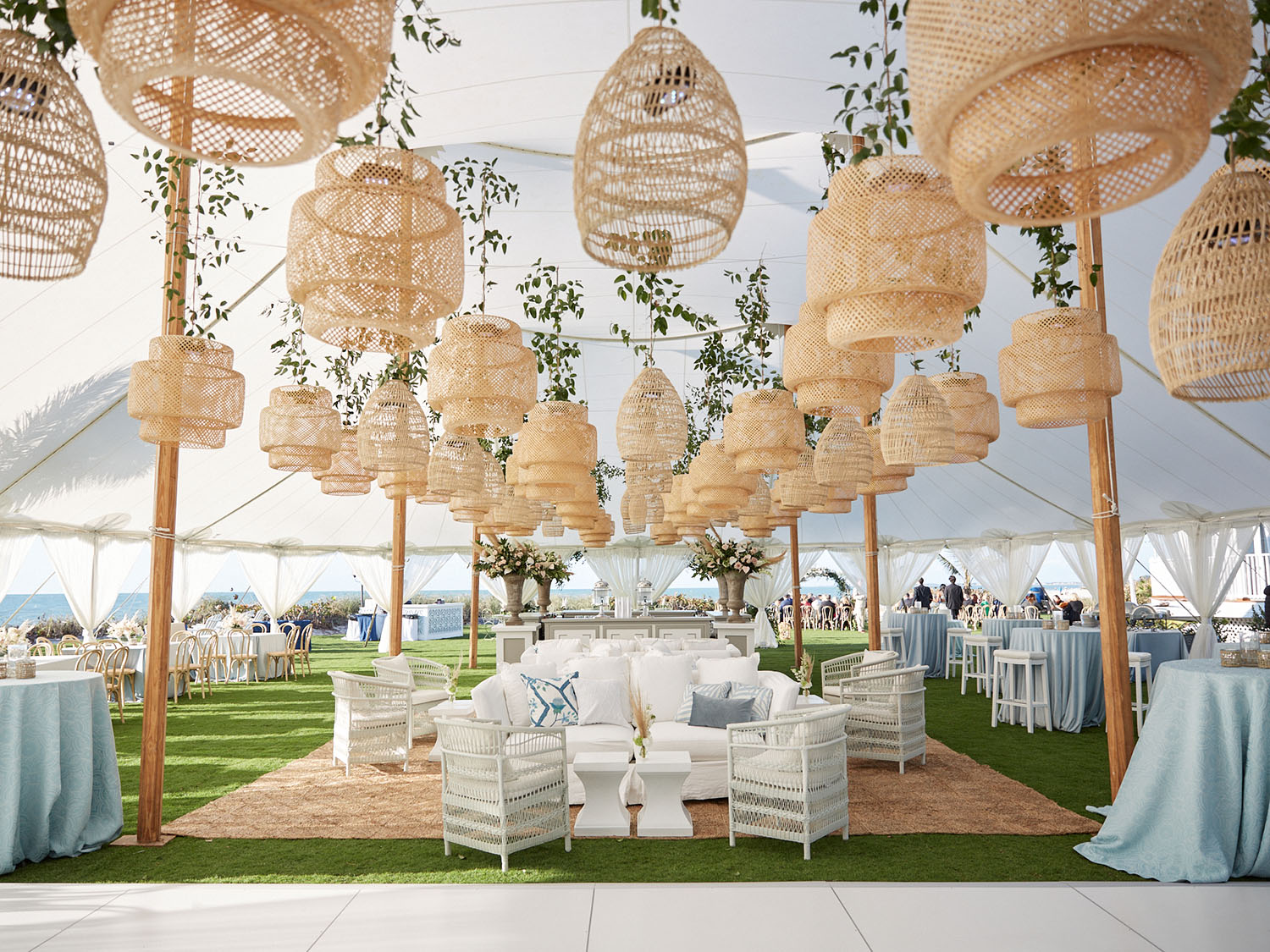 wedding tent with decorated tables and elegant wicker lanterns